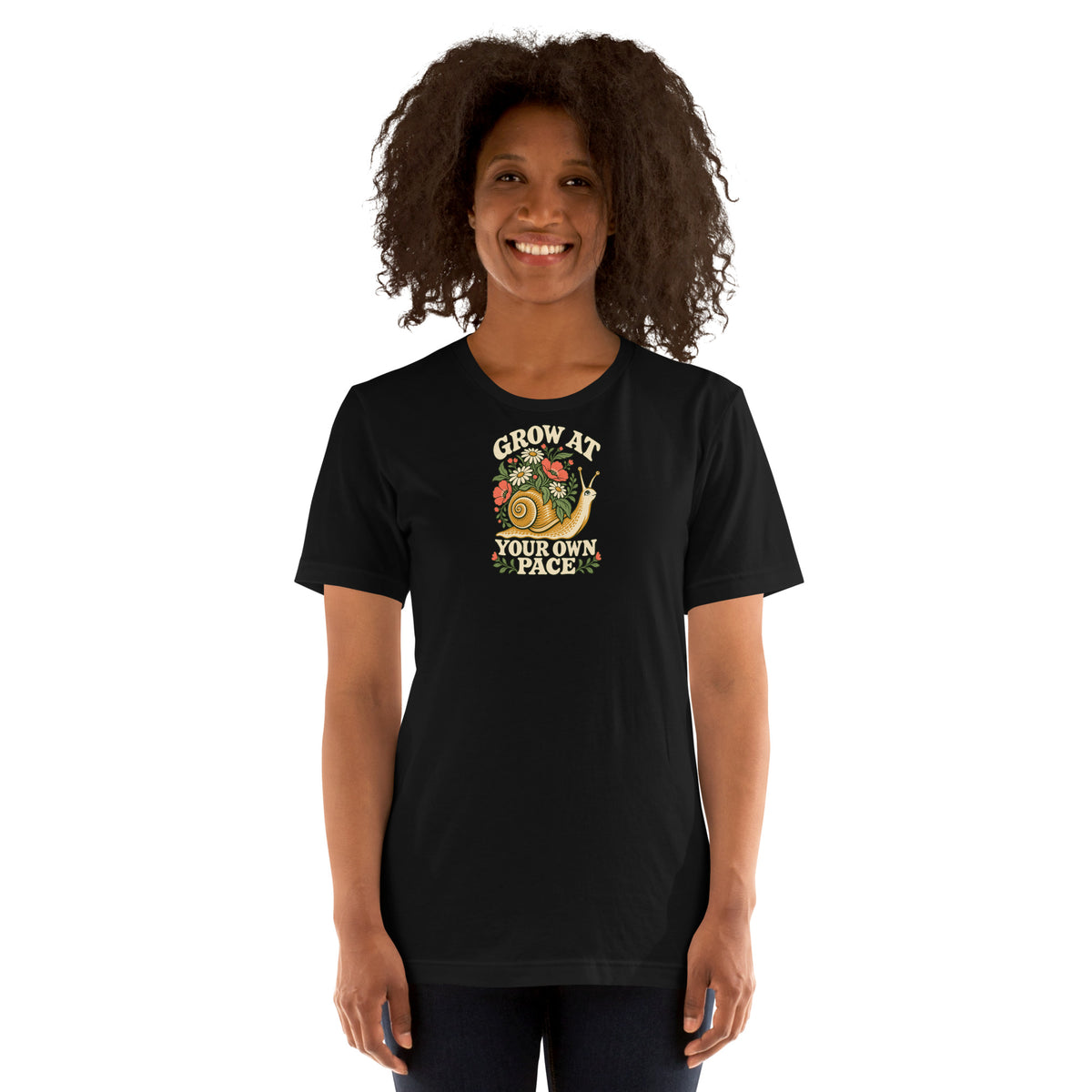 Woman modeling a black t-shirt with a flower-covered snail and the words Grow at Your Own Pace on the front.