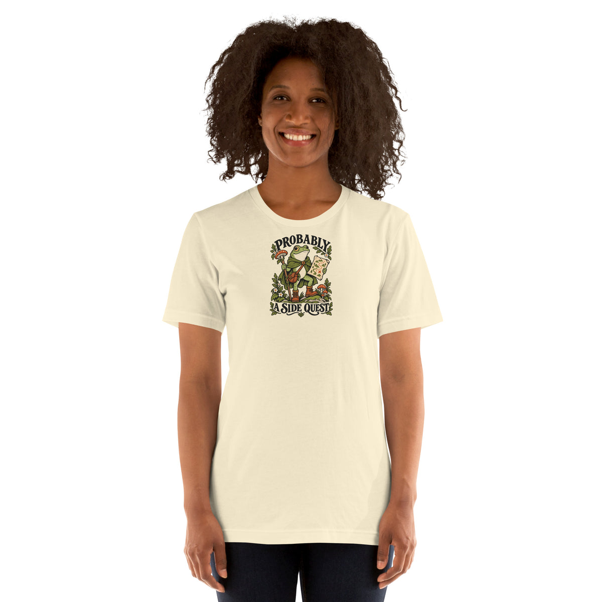 Woman modeling a natural-colored t-shirt with a frog explorer and the words Probably a Side Quest on the front.