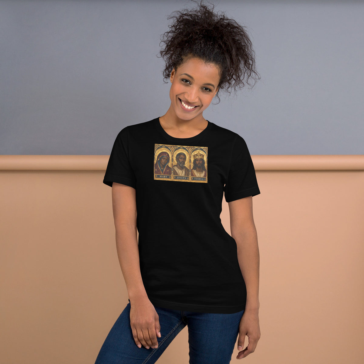 Front view of a model wearing the black Mary, Joseph & Yeshua graphic T-shirt with gold-toned devotional artwork.