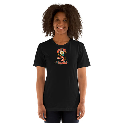 Woman modeling a black Joy Is a Practice t-shirt with a flower-headed roller skater and colorful retro lettering on the front.
