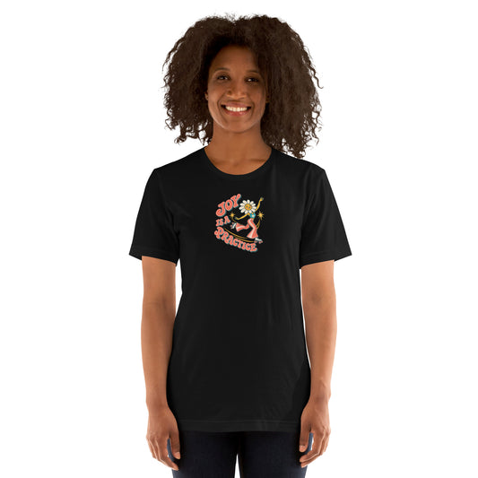 Smiling Black woman modeling the black Joy Is a Practice roller-skating flower graphic T-shirt, front view.