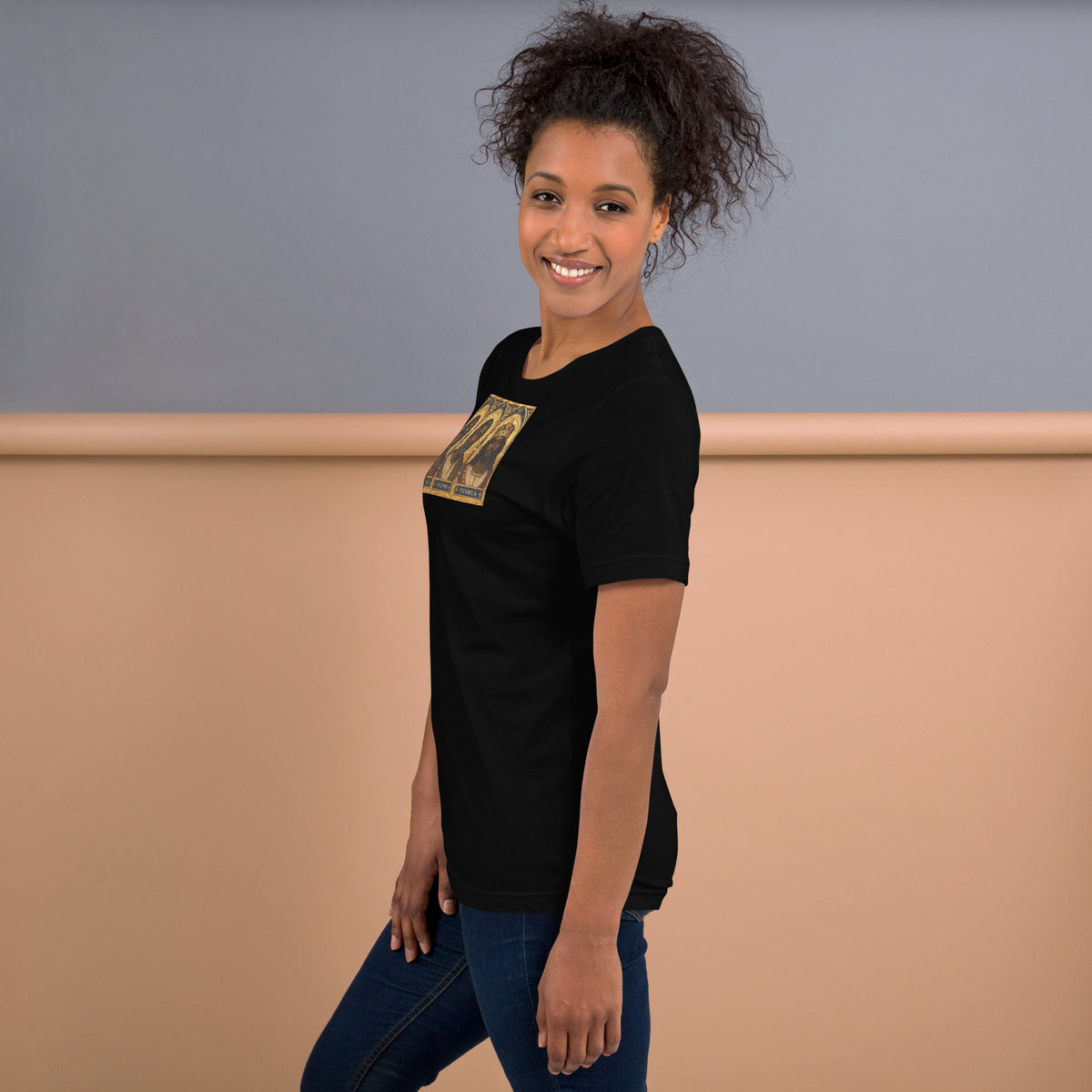 Left-side view of a model wearing the black Mary, Joseph & Yeshua graphic T-shirt.