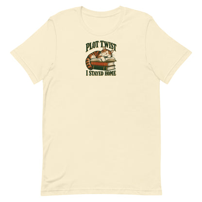 Natural cream T-shirt with a resting cat on stacked books and “Plot Twist I Stayed Home” lettering, front view.